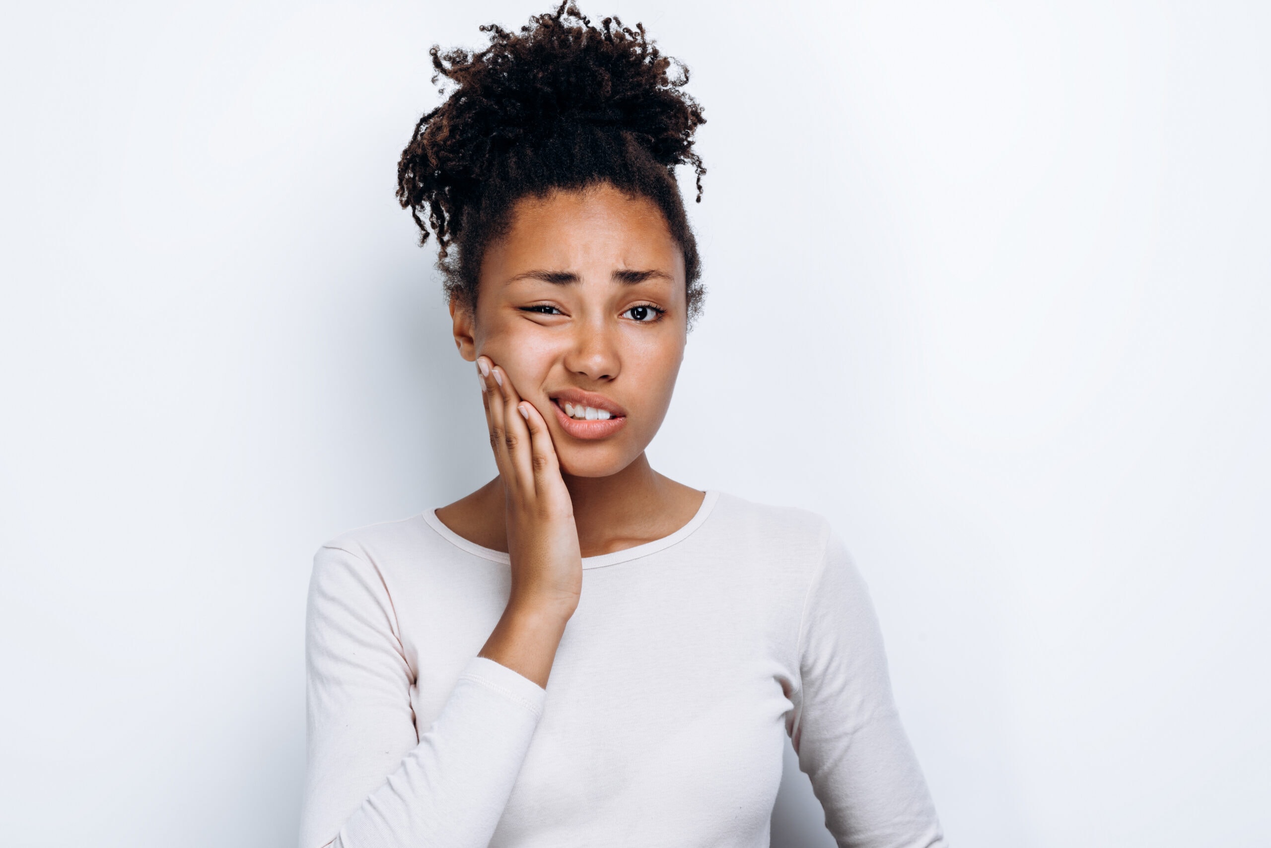 African american girl standing over isolated white background touching mouth with hand with painful expression because of toothache